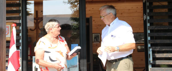 Civitan Club Grenens kasserer Oskar Schmidt overrækker Højskolesangbøgerne til Anette Andersen fra Simons Raaling. Civitan Club Grenen yder donationer